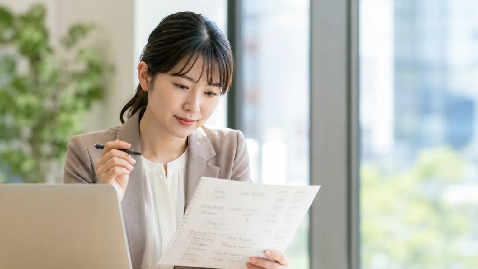 AI導入の進め方を考えるため業務の洗い出しメモを見直す担当者