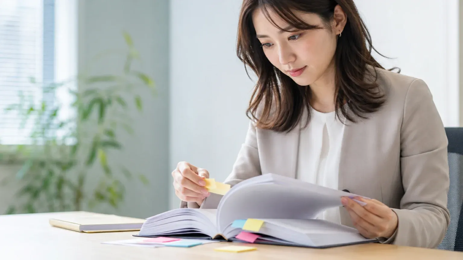 AI導入補助金の要領書に付箋を貼りながら読み込む発注担当者