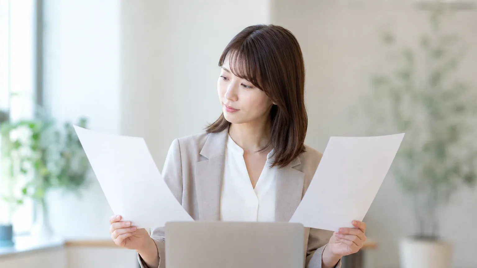 業務改善システムを既製ツールで買うか自社向けに作るか資料を見比べて検討する発注担当者