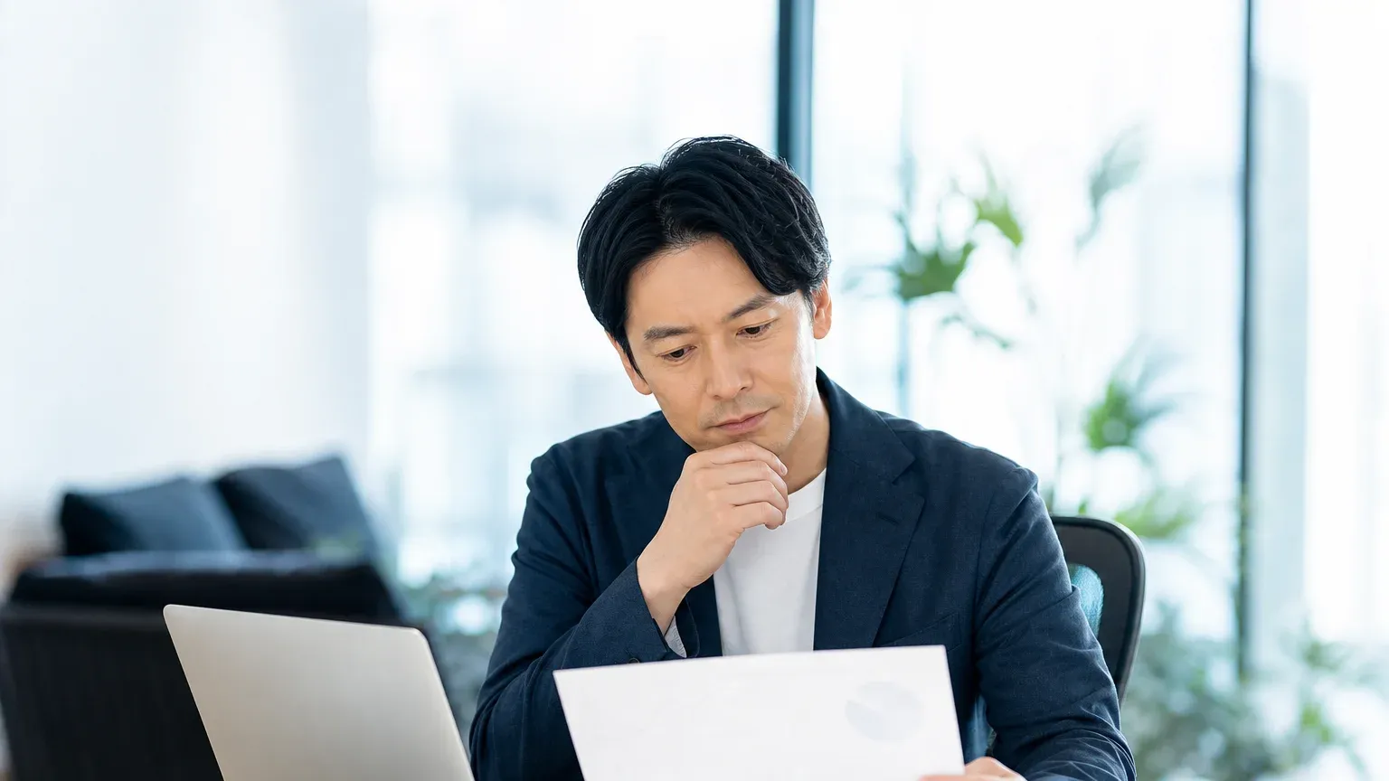 外注先の倒産リスクを示す業界動向の資料を確認する発注担当者