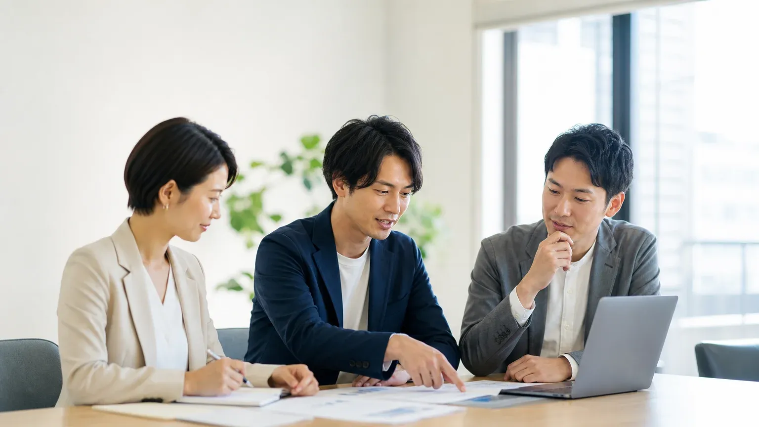 受託開発と共同開発の違いを資料で見比べながら頼み方を検討する発注担当者
