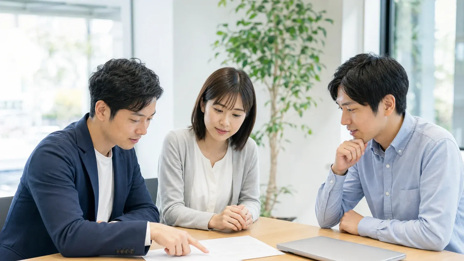請負契約と準委任契約の責任範囲を比較しながら打ち合わせる発注担当者と開発会社