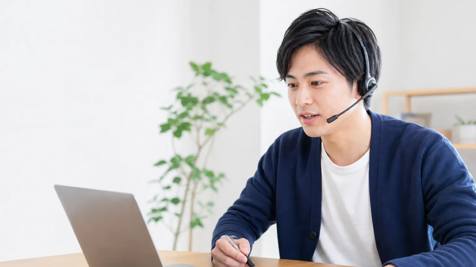 ヘッドセットを着けて支援会社に質問し、手元の質問リストで回答を確認している担当者