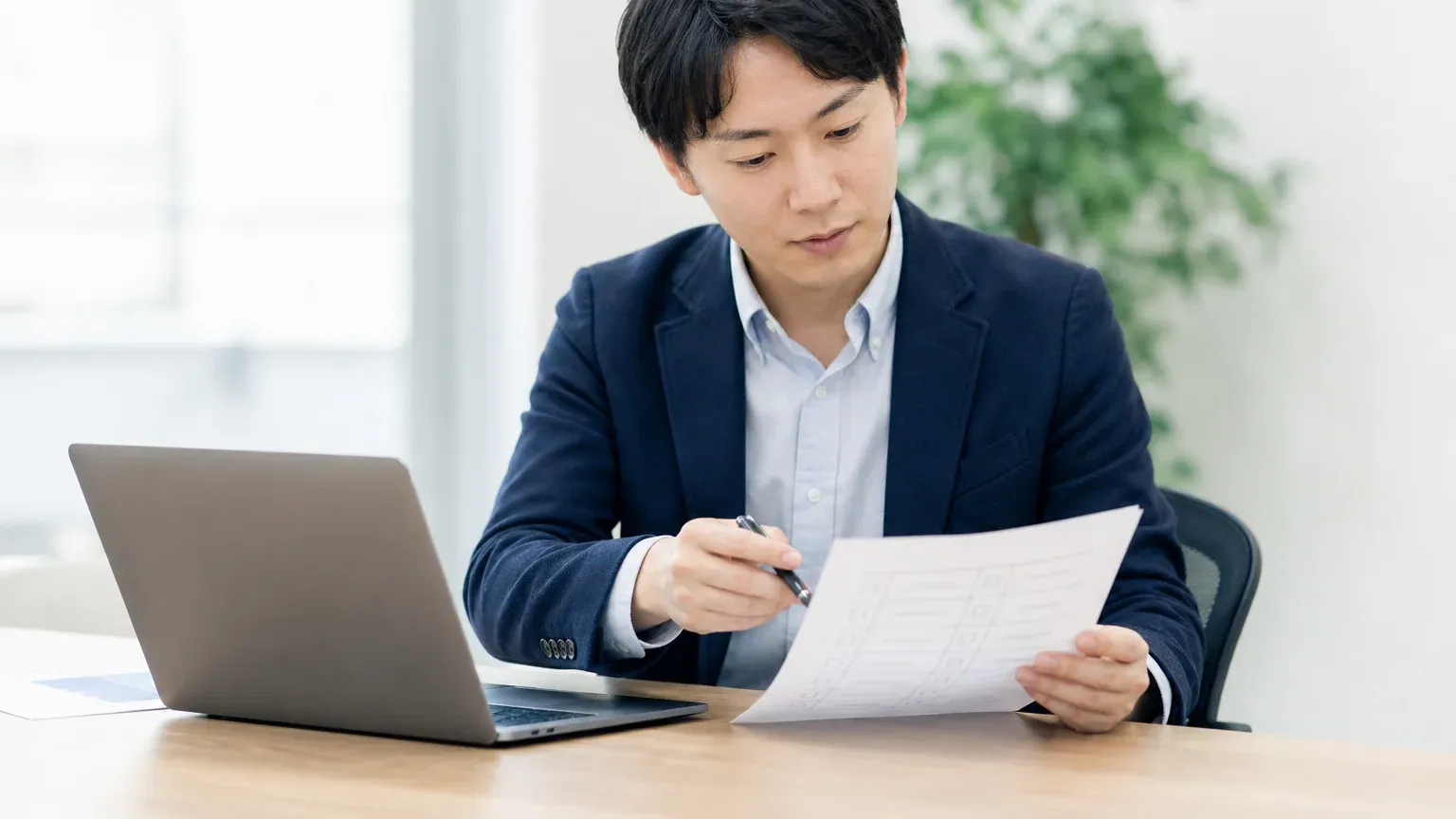 移行データの不整合や並行稼働のトラブルを示す資料を確認しながら原因を洗い出す発注側の担当者