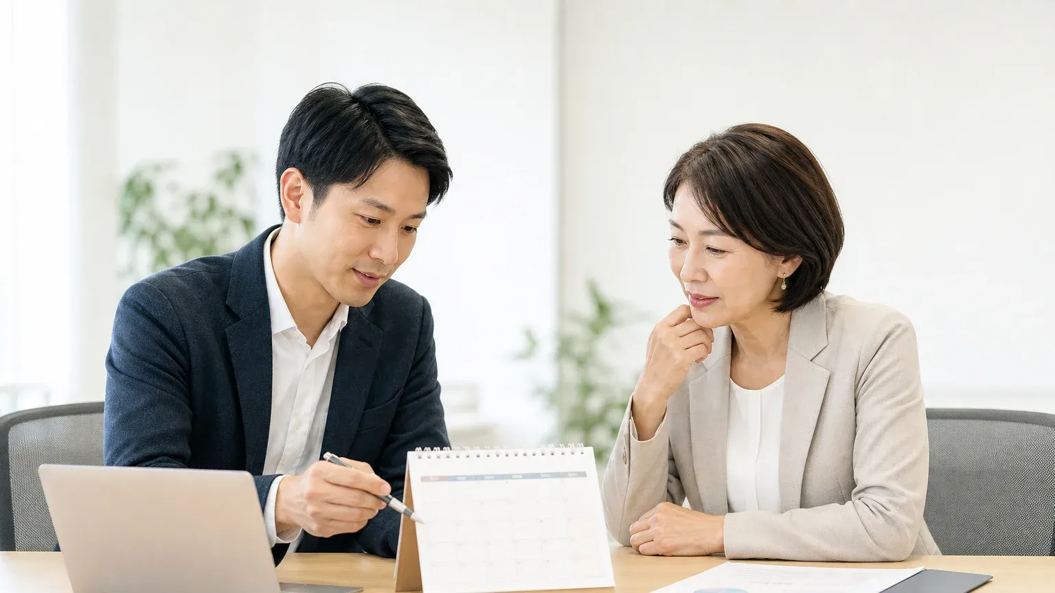 要件確定の遅れや社内承認待ちについて話し合う打ち合わせの様子