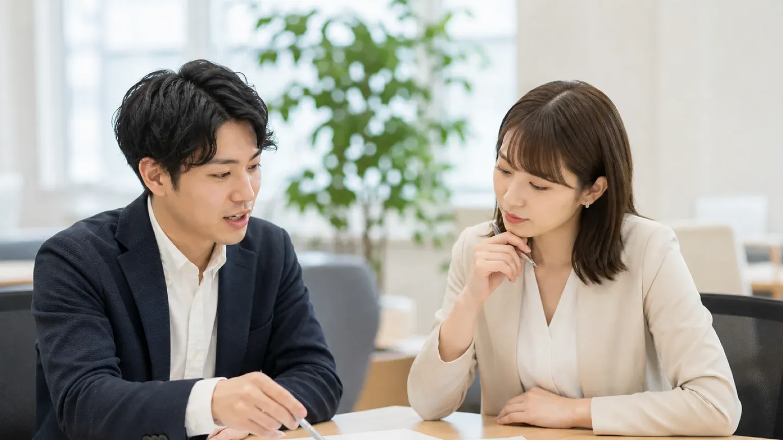 見積書を指しながら前提条件を確認し合う発注担当者とベンダー