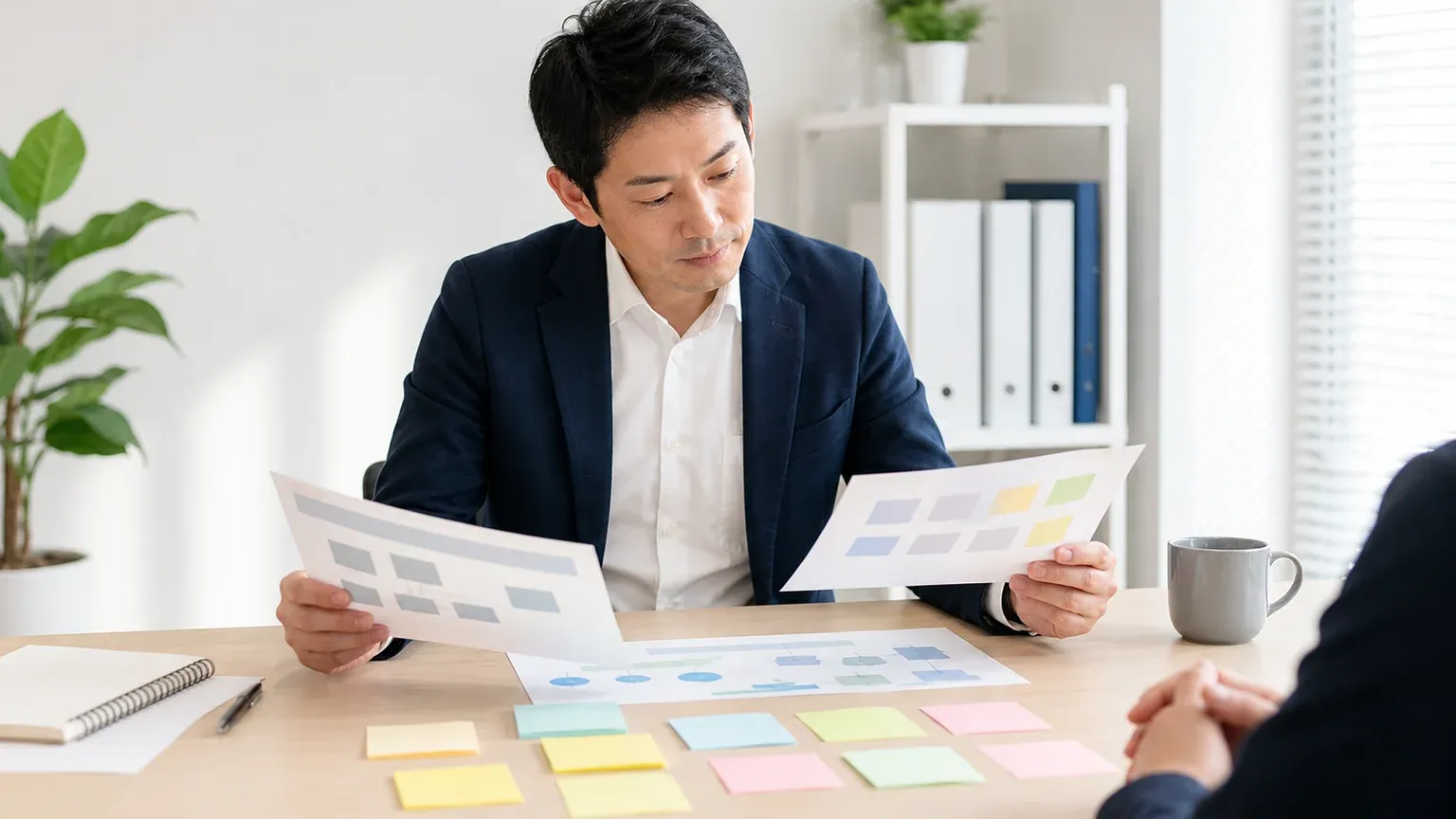 複数の資料を見比べてリーンスタートアップが自社の事業に向くか検討する担当者の手元