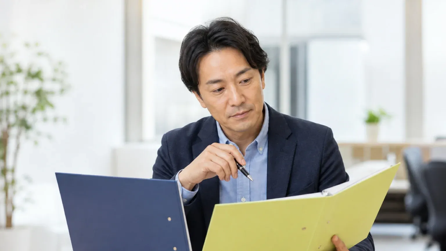 賃貸と売買の資料を並べて業務の違いを整理している不動産会社の担当者