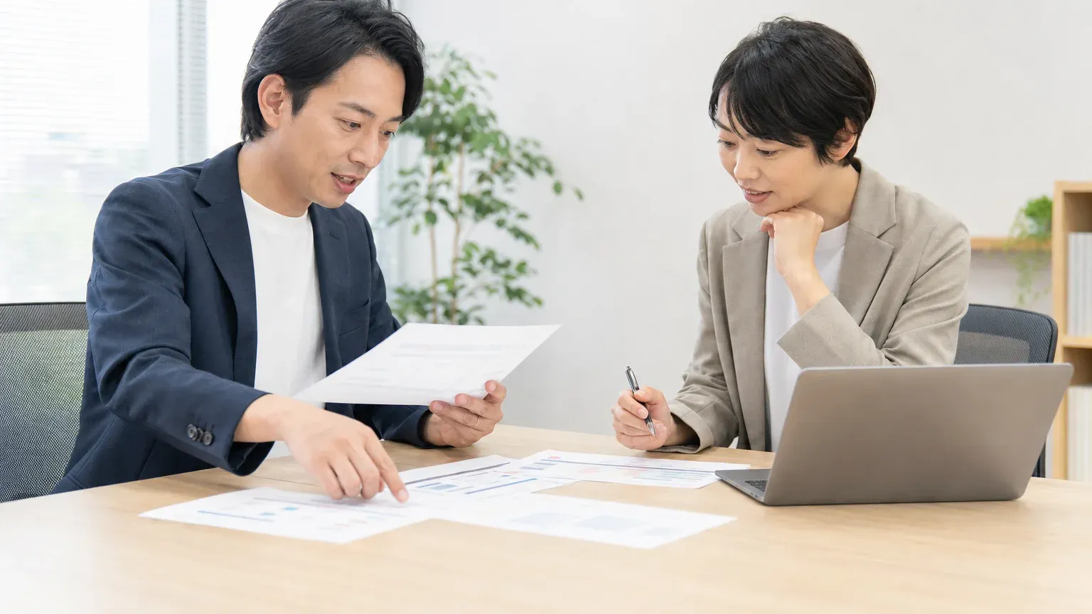 上流工程の流れを示した紙を前に、要件定義がどこから始まりどこで終わるかを発注側と開発会社で確認している場面