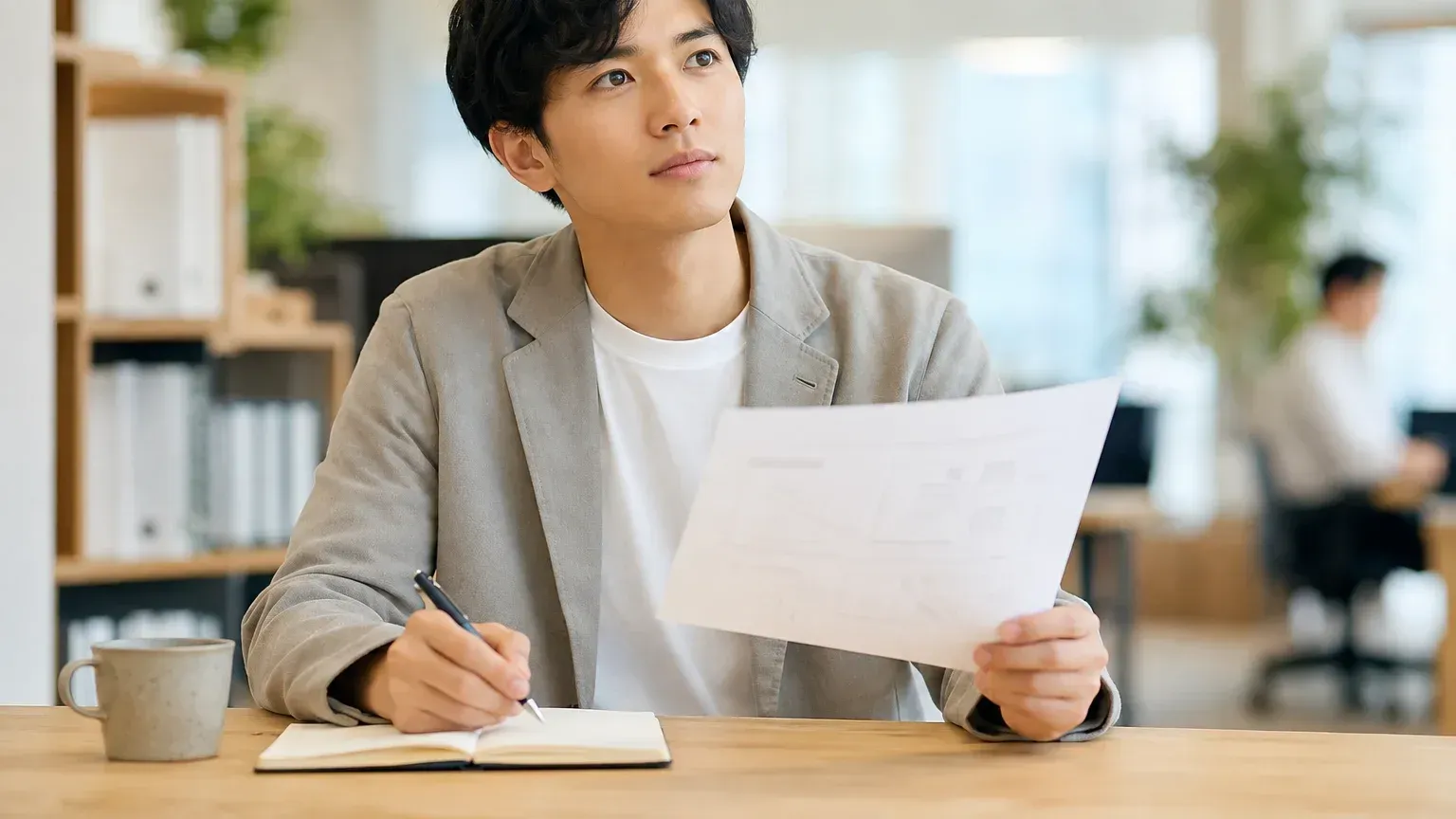 要件定義の打ち合わせで、担当者が手元の資料を見ながら業務側の条件を説明している場面