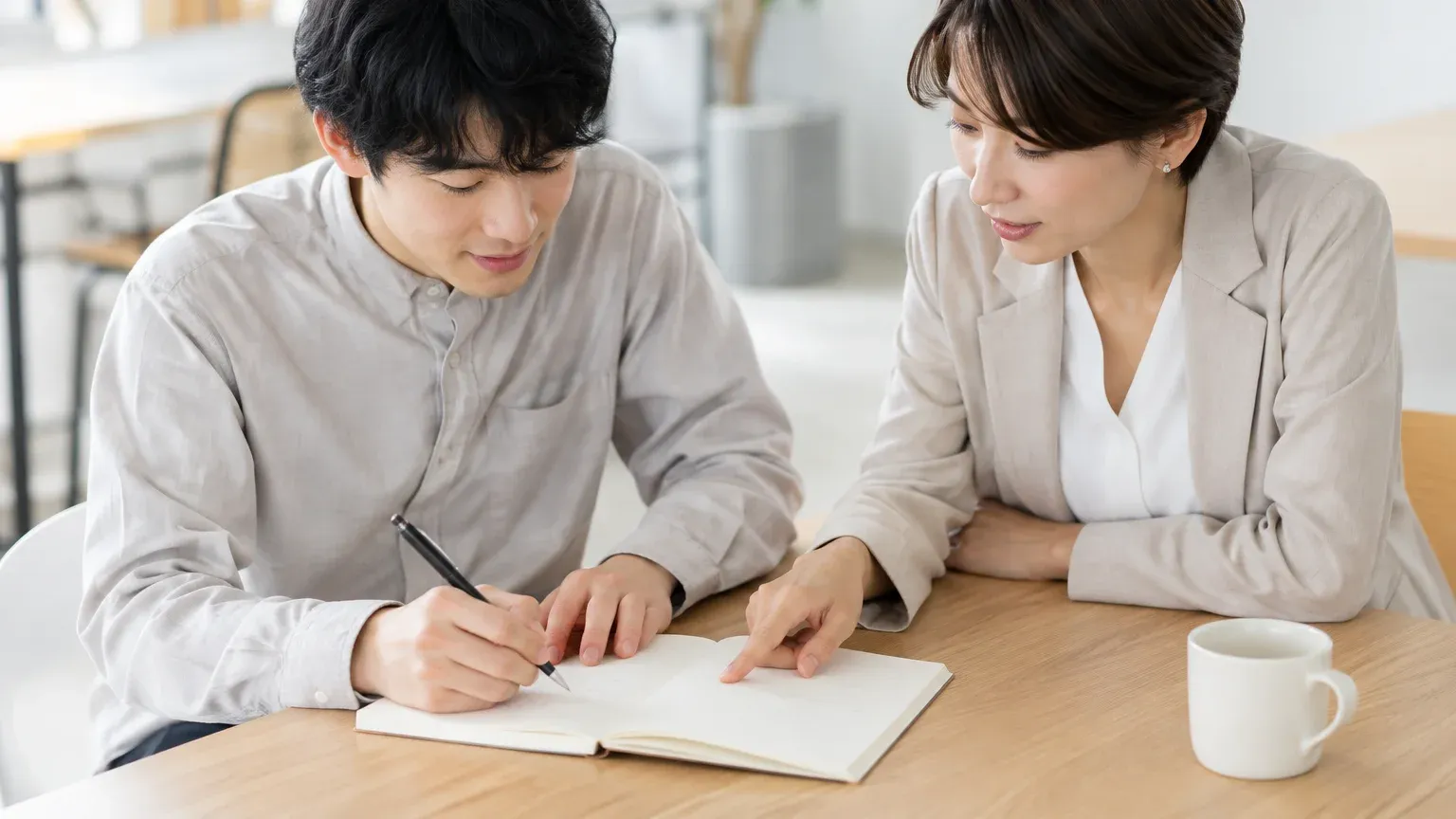 打ち合わせの場で、担当者が開発会社に確認したい項目を書き出している場面