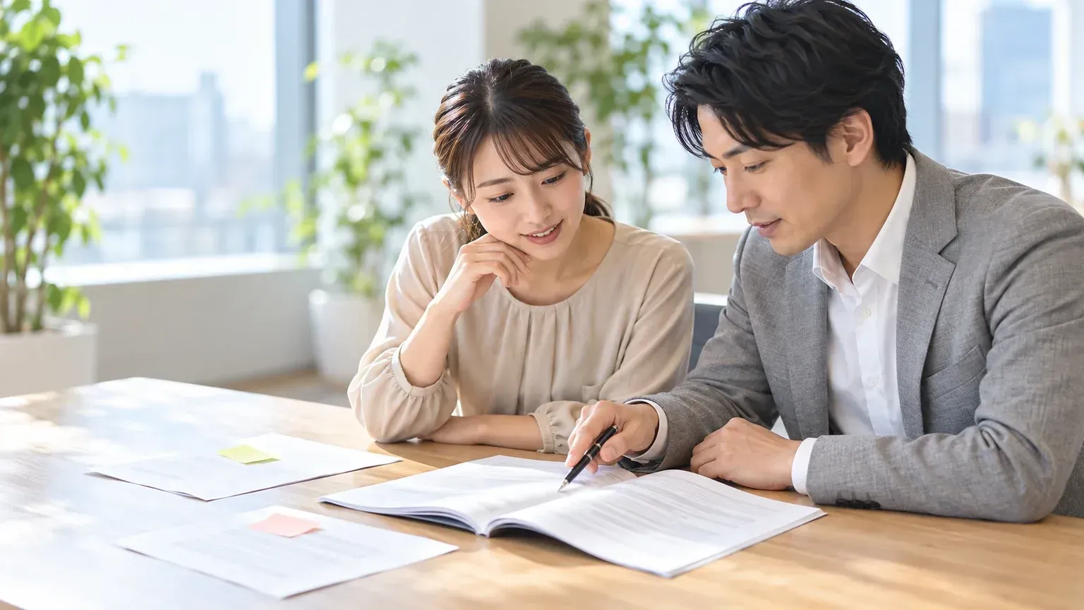 契約書の冊子を開き、損害賠償の条項を指しながら2人で確認している場面
