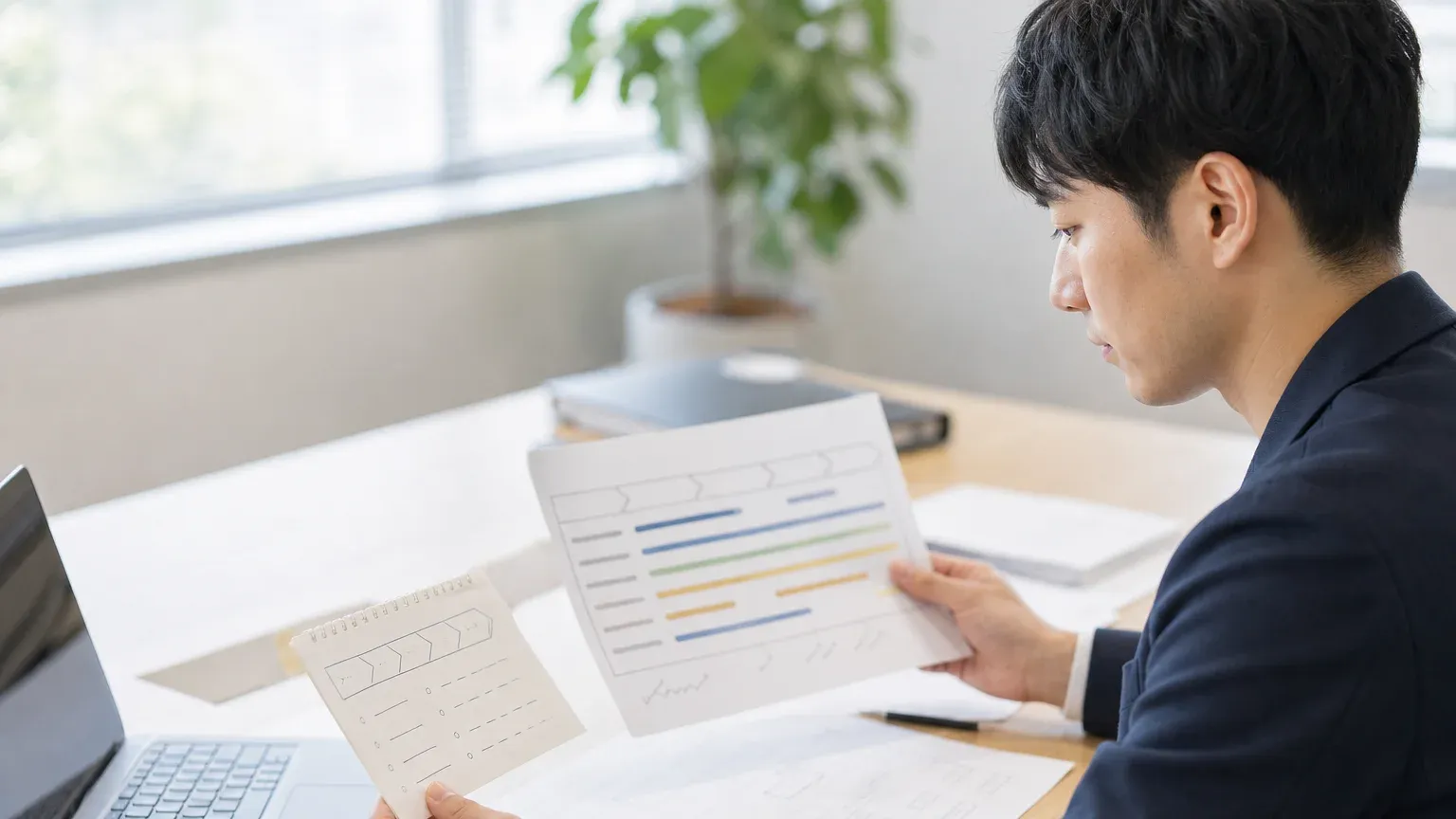 システム開発の工程の略称を一覧で確認している発注側担当者の手元