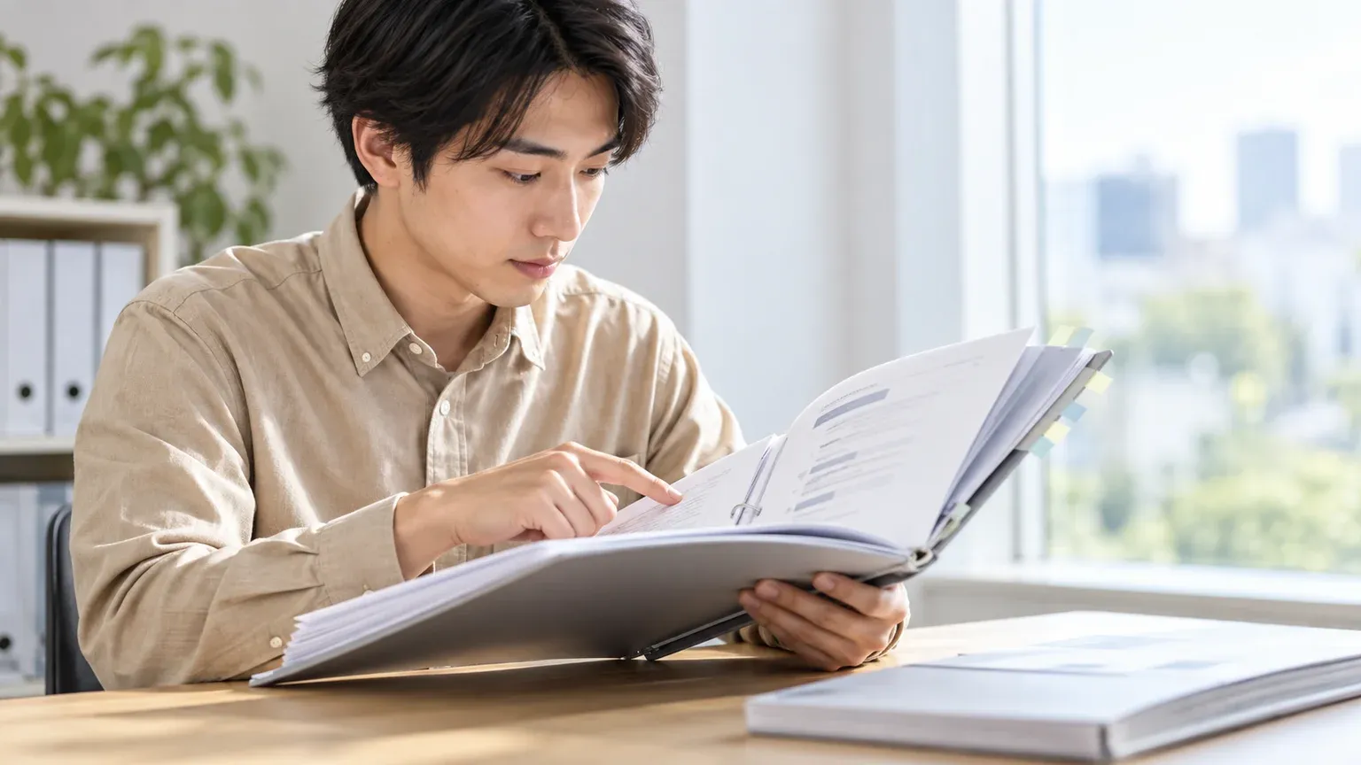 厚みのある提案書の冊子を開き、章立てのページを指で追って中身を確かめている場面